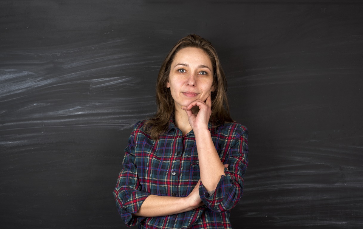 SEND teacher standing in front of chalkboard.